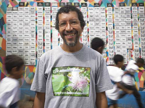 O professor de biologia Luiz Henrique Rosa em frente ao muro decorado por alunos da Escola Municipal Herbert Moses com cerca de 200 nomes de escravos Paula Giolito