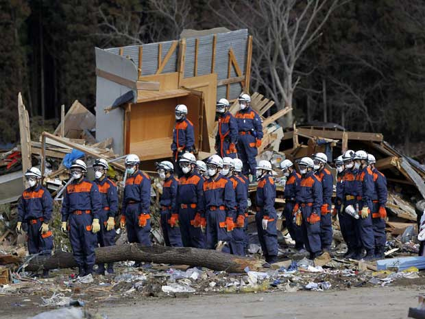 Equipe de resgate observa um minuto de silêncio em Rikuzentakata, em Iwate. (Foto: Aly Song / Reuters)