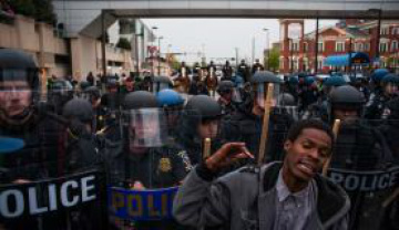 Manifestante se posiciona em frente aos policiais durante protesto contra a morte de Freddie Gray em Baltimore - Noah Scialon/EPA/Agência Brasil