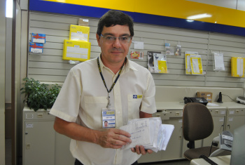 Papai Noel dos Correios de Amambai recebe 300 cartinhas todo ano O gerente da agência dos Correios de Amambai, Ramão Alex Martins, com as cartinhas que já chegaram neste ano.