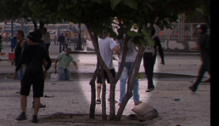 Imagens captadas pela TV Brasil mostram rapaz passando artefato  que atingiu cinegrafista (Reprodução TV Brasil)