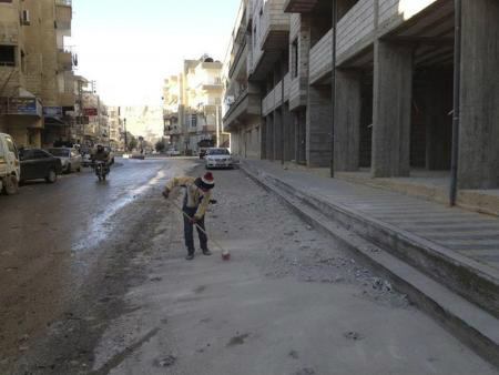 Menino varre a rua próximo a prédio danificados pelo que ativistas disseram ter sido um bombardeio de forças leais ao presindete da Síria, Bashal al-Assad, em Yabroud, próximo a Damasco. 