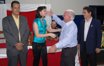 Rotary de Amambai realiza reunião festiva Alexandre (E), Marta recebendo os cumprimentos de seu padrinho, Aparício Ormay, e Pedro Humberto.