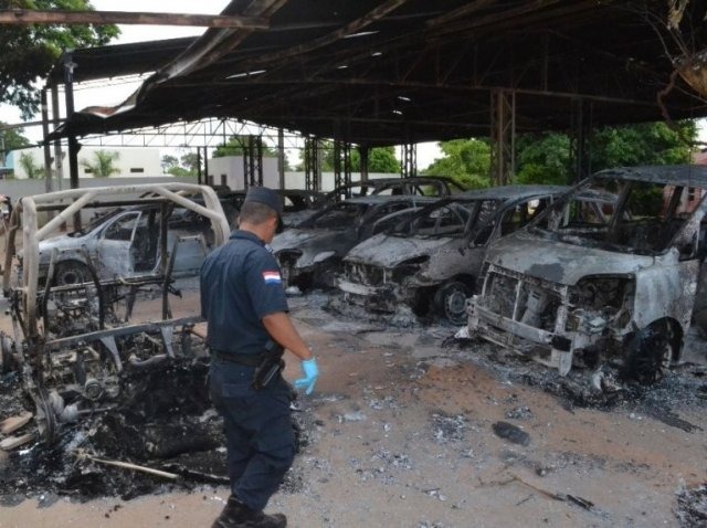 Policial observa carros destruídos em loja da família Alderete (Foto: ABC Color)