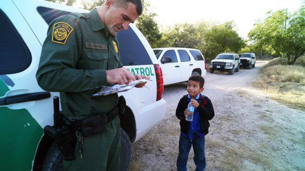 Um agente da Guarda da Fronteira com Alejandro, 8, que viajava sozinho através do Rio Grande – Foto: Reprodução / Jennifer Whitney para o New York Times