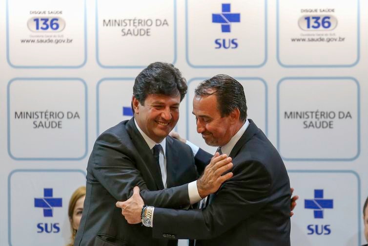 O  atual  e  o  ex-ministro  da  Saúde,  Luiz  Henrique  Mandetta  e  Gilberto  Occhi,  respectivamente,  cumprimentam-se  na  cerimônia  de  transmissão  de  cargo  -  Fabio  Rodrigues  Pozzebom/Agência  Brasil