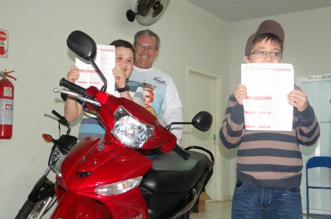 Ganhadores de uma das motos sorteadas no bingo de 2014 com Branco Escobar.