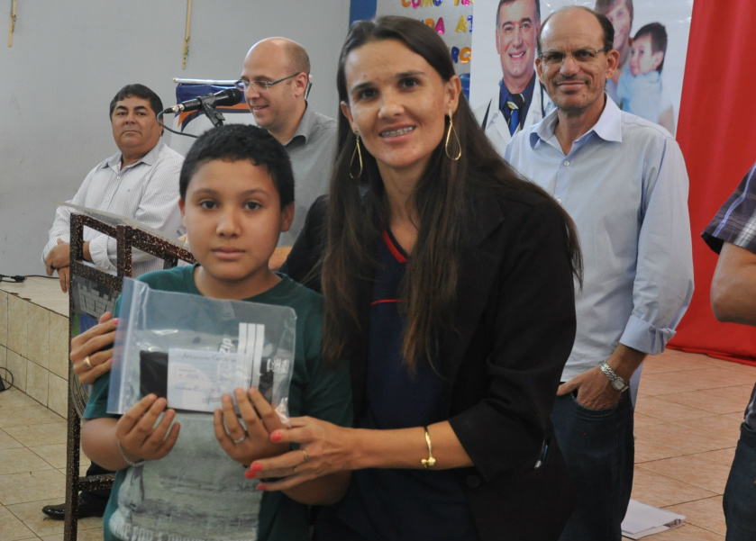 Vera Lorensetti, secretária de Educação, entregando óculos para criança / Foto: Assessoria