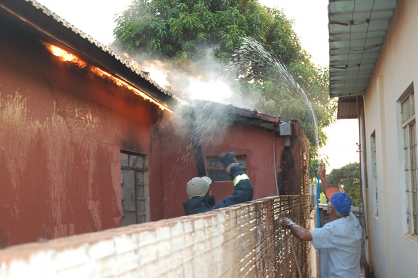 No fim da tarde dessa terça-feira (9), casa pega fogo em Amambai Vizinho auxiliam bombeiros a conter o fogo, que se alastrava do interior em direção ao telhado da casa.