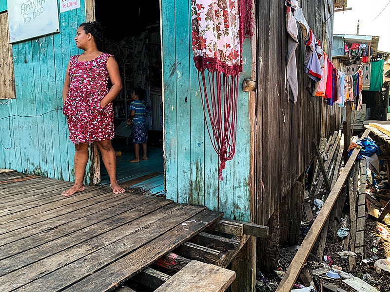 Rosana dos Santos, 24 anos, com o filho na porta da sua casa na Vila da Barca, em Belém, é uma das pessoas que se enquadram no projeto de renda mínima proposto pelo prefeito Edmilson Rodrigues (PSOL) - Catarina Barbosa/Brasil de Fato