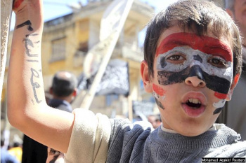 Criança com a bandeira síria pintada no rosto e a inscrição 
