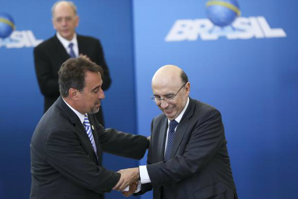 Occhi quer retomar obras do Minha Casa, Minha Vida paradas por falta de verba O presidente da Caixa, Gilberto Occhi, recebe cumprimentos do ministro da Fazenda, Henrique Meirelles, durante cerimônia de posse no Palácio do Planalto
