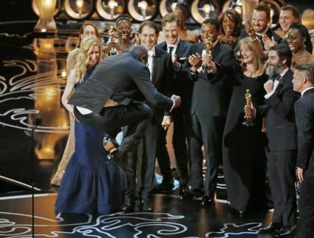 O diretor e produtor Steve McQueen pula para comemorar o Oscar de melhor filme para 