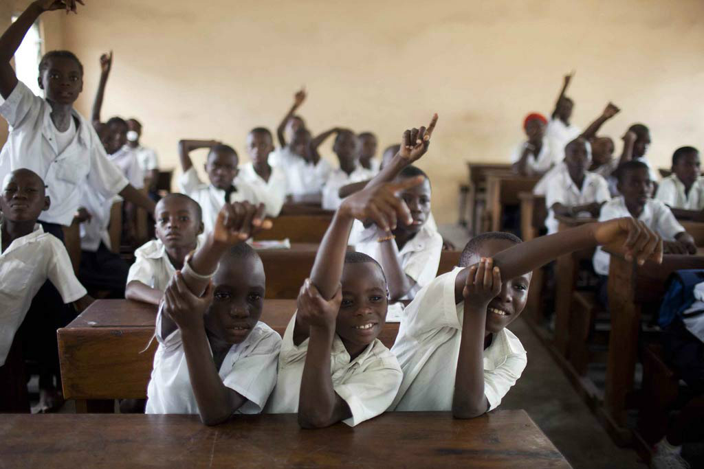 Estudantes de escola primária na República Democrática do Congo levantam as mãos para responder perguntas. Foto: Banco Mundial/Dominic Chavez