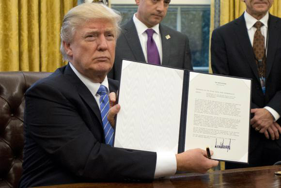 Washington – Donald Trump assina decreto que retira os Estados Unidos do Acordo Transpacífico, assinado em outubro de 2015 por mais 11 países (Foto: Ron Sachs/Pool/Agência Lusa)