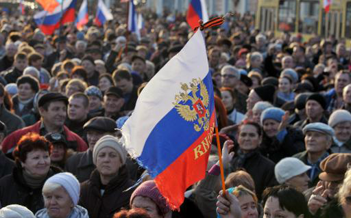 (5 mar) Ativistas agitam uma bandeira russa na cidade de Yevpatoria, Crimeia (AFP, Genya Savilov)