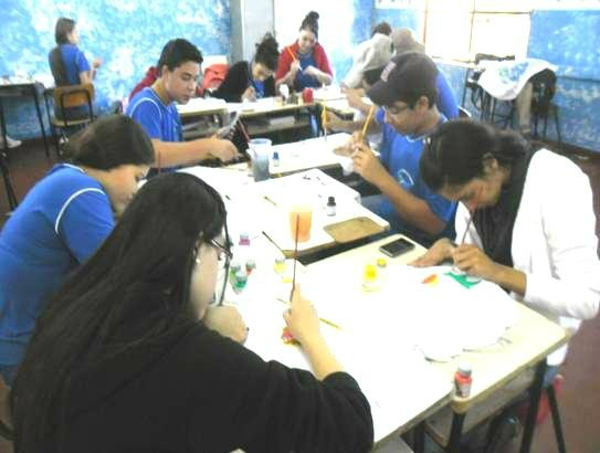 Amambai, 65 anos: Qualidade na Educação é marca registrada do município Alunos do Ensino Médio realizando a pintura das camisetas Foto: Reprodução