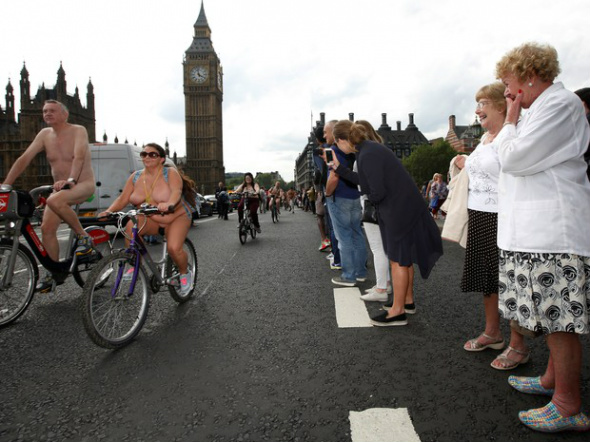 Ciclistas pelados protestam em Londres e atraem olhares curiosos Mulheres observam ciclistas sem roupa durante pedalada em Londres / Foto: REUTERS/Luke MacGregor