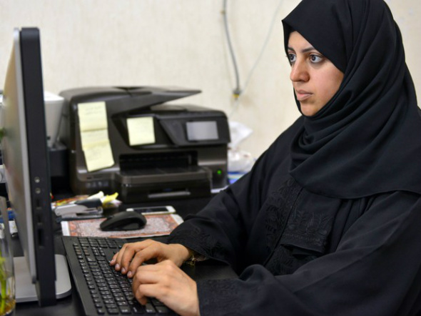 Nassima al-Sadah, candidata a uma vaga no conselho municipal de Qatif, é vista trabalhando em seu escritório, na quinta (26) (Foto: AFP Photo/STR)