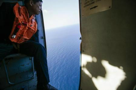 Um militar olha para fora de um helicóptero durante uma missão de busca e resgate saindo da ilha vietnamita de Tho Chu. 