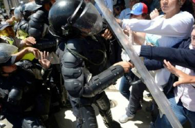 Trabalhadores da saúde pública venezuelana brigam com a polícia de choque durante um protesto em Caracas. (Foto: Juan Barreto/AFP)