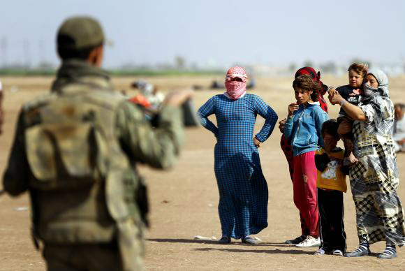 Refugiados sírios aguardam na fronteira com a Turquia para fugir dos ataques do Estado IslâmicoEPA/Sedat Suna/Agência Lusa