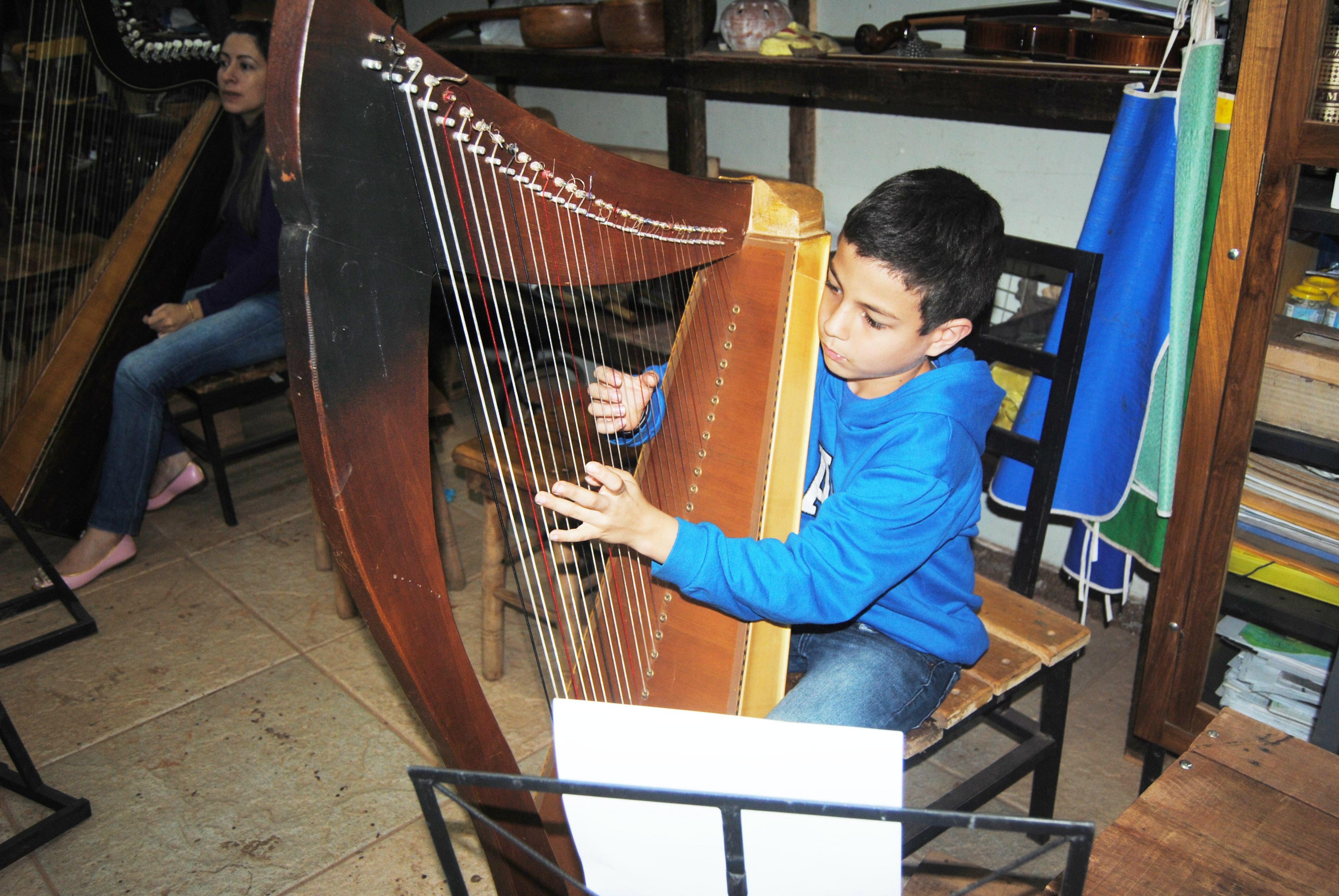 Davi aprendendo a tocar harpa / Foto: Moreira Produções