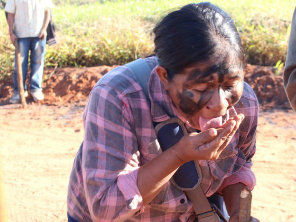 PF e Força Nacional fazem perícia em fazenda de Caarapó ocupada por índios Guarani-kaiowá lambe terra em sinal de que vão lutar até o fim por terra / Foto: Gabriela Pavão/G1 MS