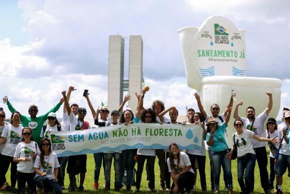 Manifestantes inflam um vaso sanitário gigante em frente ao Congresso Nacional para simbolizar a falta de saneamento básico no paísMarcelo Camargo/Agência Brasil