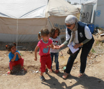 Crianças deslocadas com funcionária da OMS. Foto: OMS Iraque