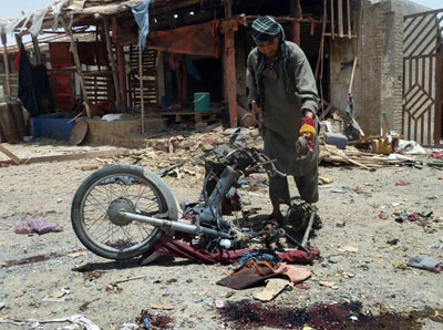 Afegão observa moto-bomba usada no ataque desta quarta (6)