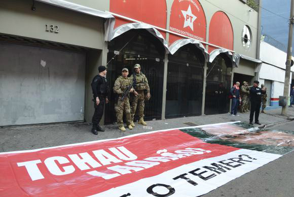 Membros do PT em São Paulo protestam contra buscas da PF na sede do partido São Paulo - A Polícia Federal cumpre mandado de busca e apreensão como parte da Operação Custo Brasil na sede do Partido dos Trabalhadores, na capital paulista