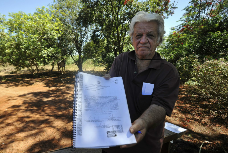 Produtor rural Raul das Neves, dono de uma fazenda no Mato Grosso do Sul,mostra o documento de sua terra. Demarcação pela Funai anula o título. (Foto: Marcello Casal Jr., da Agência Brasil.)