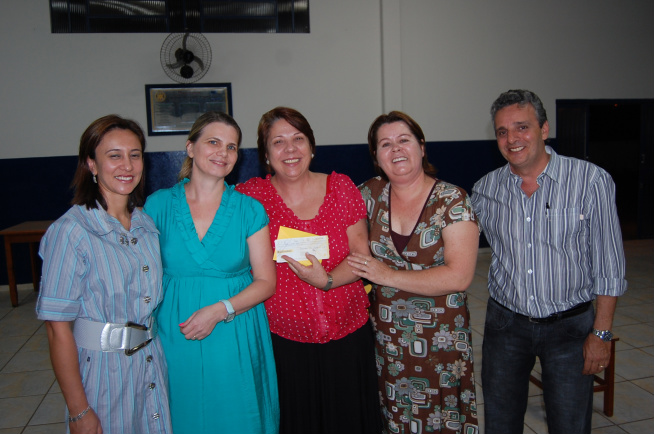 Rotary de Amambai promove Jantar Italiano Ao centro, Vila Selhorst com o cheque do Rotary, Roberto Protético, Zaira, Cleuza e Elizandra.Moreira Produções / Amambai Notícias