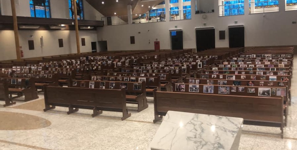Paróquia cola fotos de fiéis em bancos da igreja para celebrar missa, em Amambai Fiéis foram representados por fotos de família / Foto: Sirlley Escobar