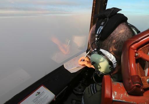 Tenente da Força Aérea Real australiana faz anotações durante as buscas, no sul do Oceano Índico (Pool/AFP, Rob Griffith)